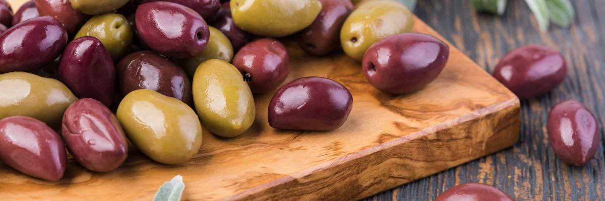 Deska niedrylowanych oliwek. Obrazek w artykule Czy oliwki to warzywa? Wyjaśnienie i odpowiedź na pytanie czy oliwki to warzywa